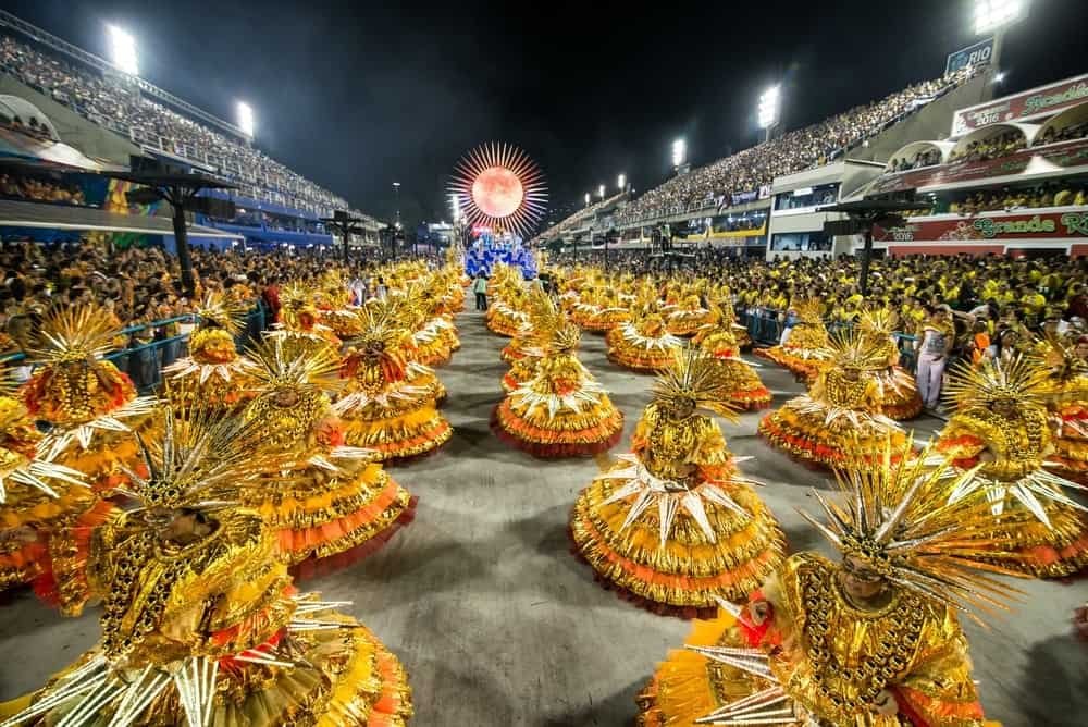 Elementos que compõem uma escola de samba - Fonte: https://olhardigital.com.br/2023/02/16/internet-e-redes-sociais/desfile-das-escolas-de-samba-de-sp-e-rj-como-assistir-datas-e-horarios/ 